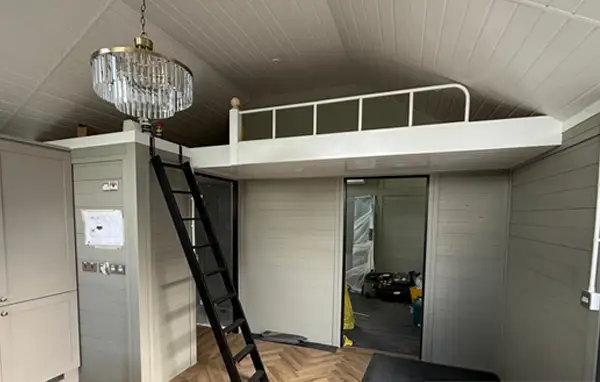 Timber mezzanine storage platform with a ladder inside an annexe