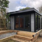 Composite Garden Building With Decking In Garden And Gravel Lacing The Ground